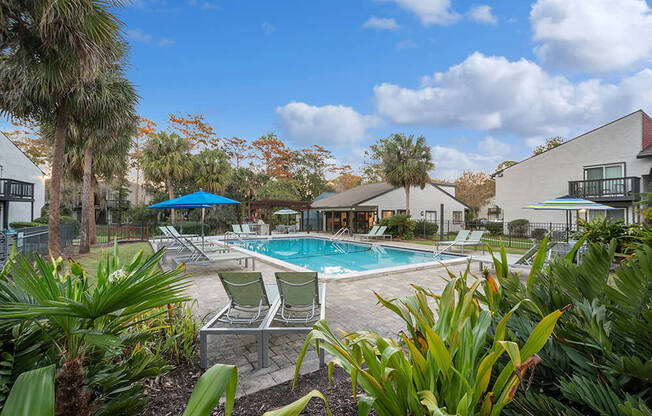 Community Swimming Pool with Pool Furniture at Heron Walk Apartments in Jacksonville, FL.