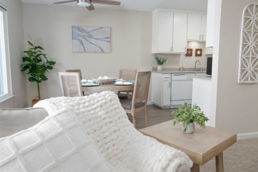 Model apartment living room with a couch and a table and a kitchen