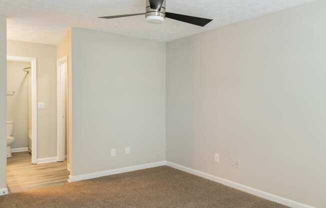 Bedroom with ceiling fan and carpet at Twin Springs Apartments, Norcross, GA