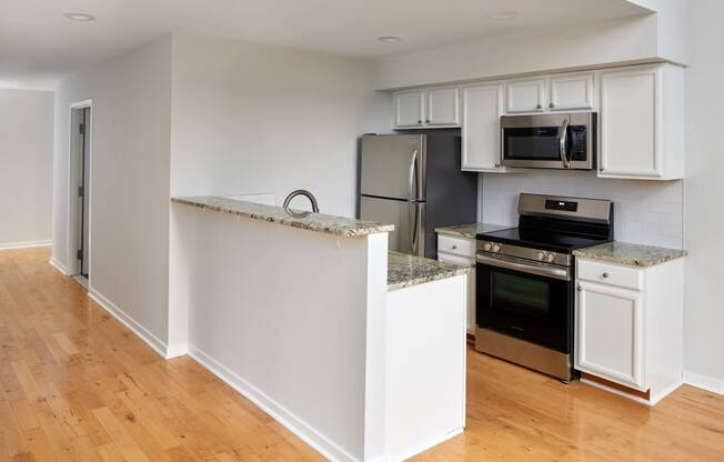 a kitchen with white cabinets and stainless steel appliances