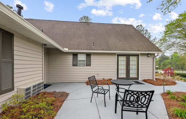 a patio with a table and chairs in front of a house