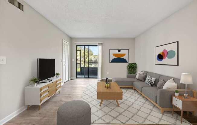 a living room with a gray couch and a coffee table with a television on top of it