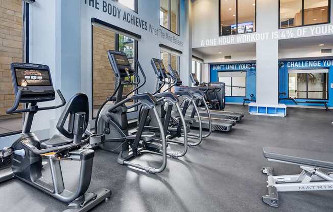 A gym with a row of exercise bikes and a sign that says