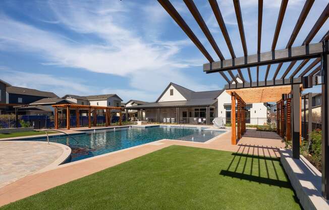 a large swimming pool with a house in the background