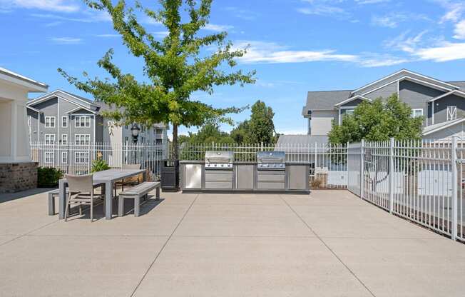 a patio with a table and chairs in front of a fence