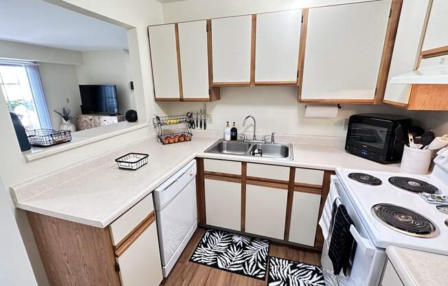 an empty kitchen with white cabinets and a stove and sink