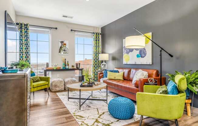 a living room with a brown couch and yellow chairs