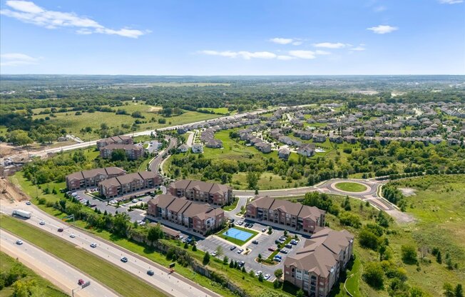 A bird's eye view of a residential area with apartment buildings and a highway.