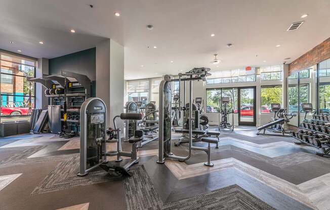A gym with a variety of equipment including treadmills, weights, and exercise machines.