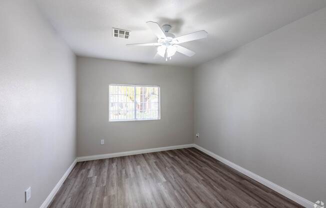 A room with a ceiling fan and a window.