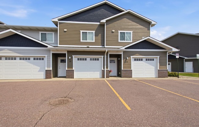 A row of houses with garages and driveways.