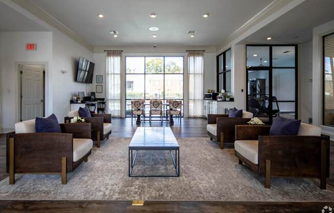 A spacious living room with a central coffee table and multiple seating options.