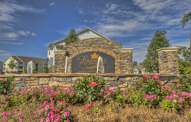 Lullwater at Blair Stone entrance sign with lush pink flowers and fountain