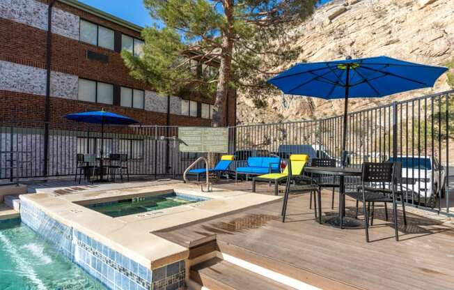 a resort style pool with tables and umbrellas next to a building
