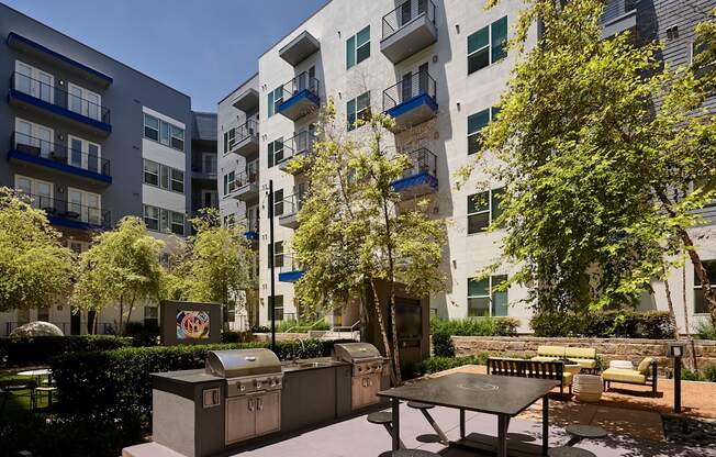 an outdoor patio with a picnic table in front of an apartment building
