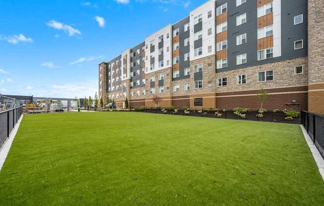 A large grassy area in front of a multi-story building.
