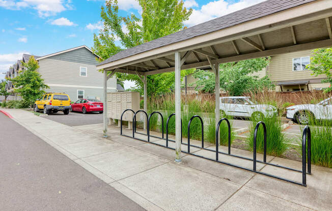 a covered parking lot with cars parked in front of a house