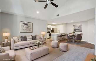 A living room with a white couch and a ceiling fan.