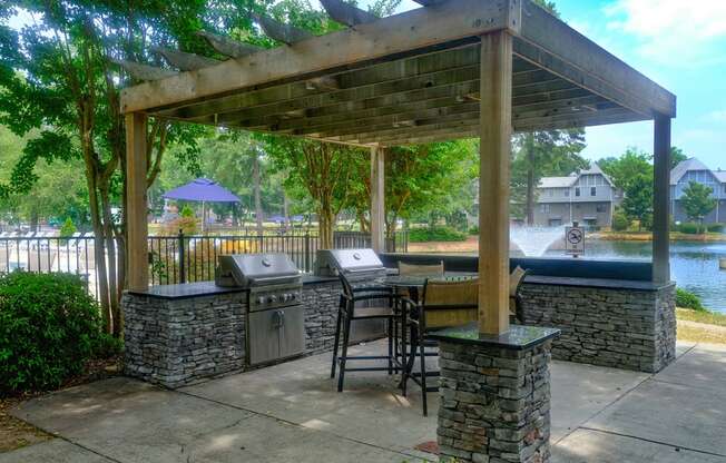 a covered patio with a grill and a table with chairs