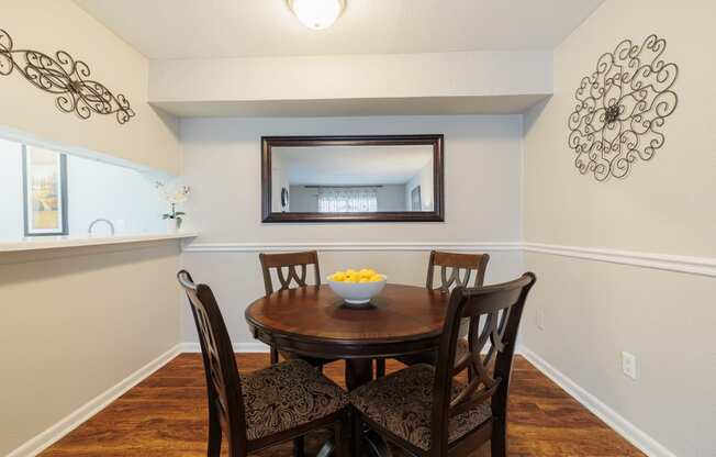 a dining room with a table and chairs and a mirror