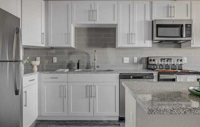 a kitchen with white cabinets and granite counter tops