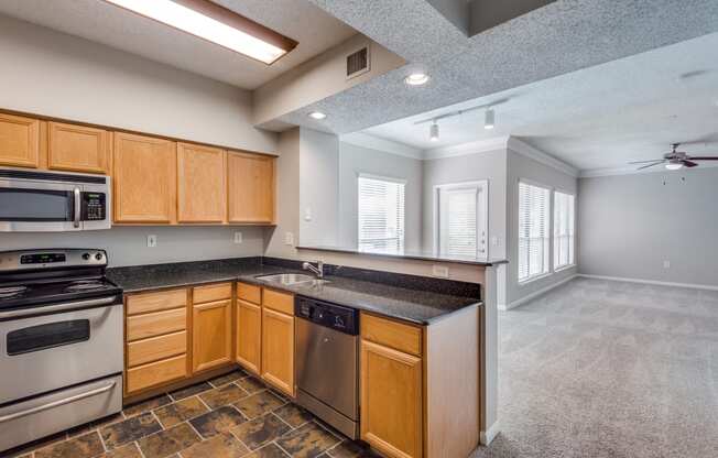 an empty kitchen with wooden cabinets and stainless steel appliances