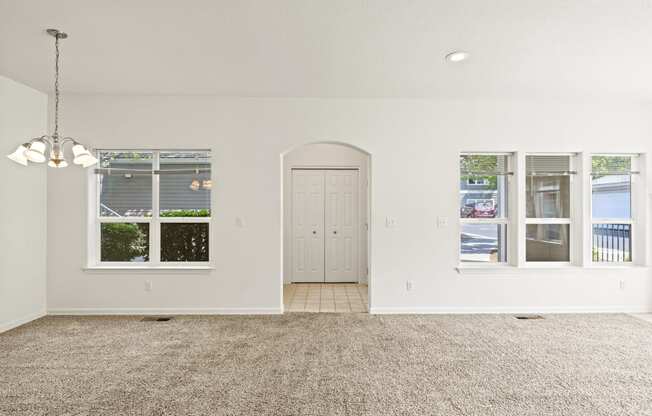 a living room with white walls and a carpeted floor