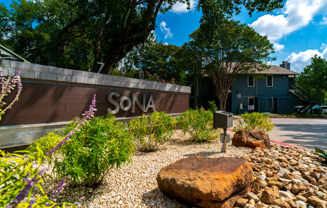 a yard with rocks and a sign in front of a house