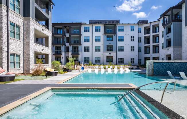 a swimming pool with an apartment building in the background