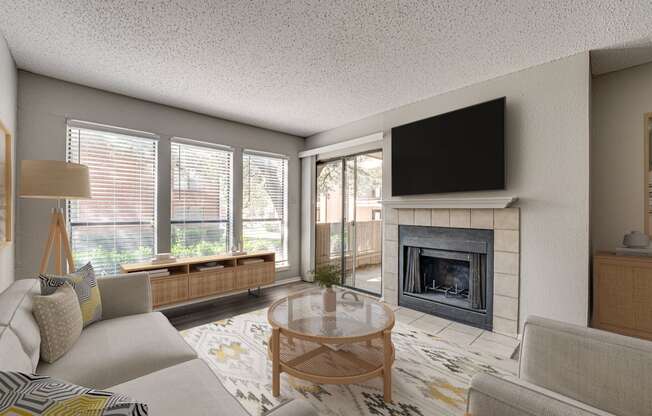A living room with a fireplace and a flat screen TV mounted above it.