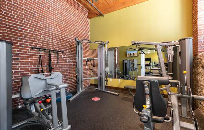 a gym with weights and a brick wall