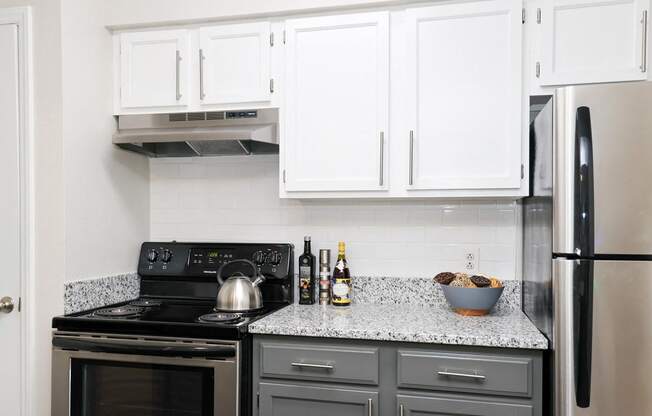 a kitchen with white cabinets and black appliances and a granite counter top