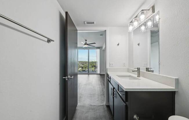 A bathroom with a black door and a white counter.
