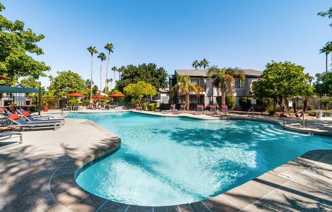 Pool with apartment building and tree in background