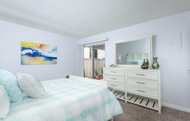 a bedroom with a bed and a dresser and a mirror