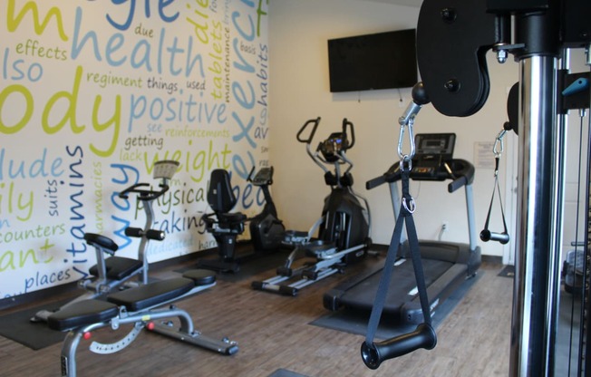 a workout room with weights and a wall with writings on it