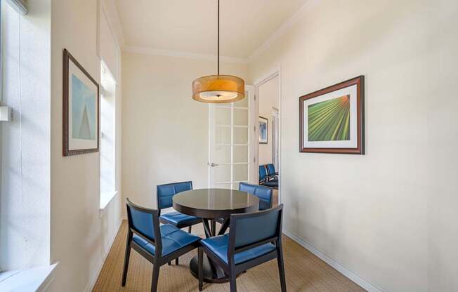 A dining room with a round table and chairs.