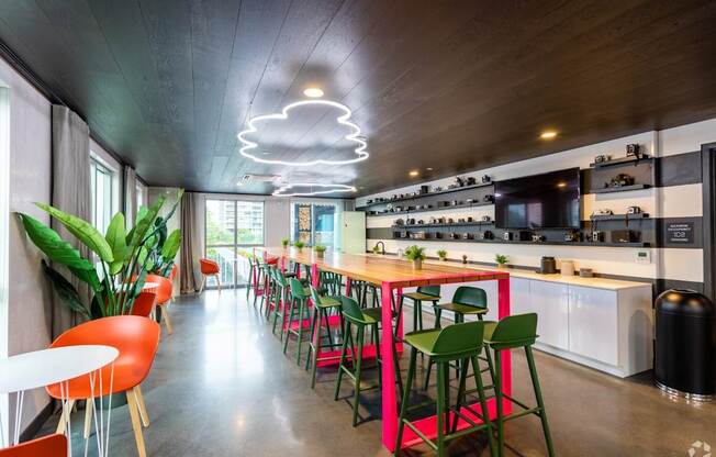 A modern kitchen with a long table and chairs.