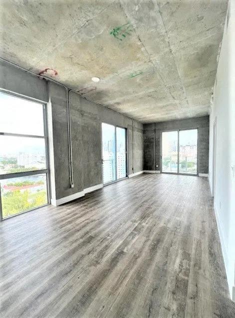 an empty living room with wood floors and a large window