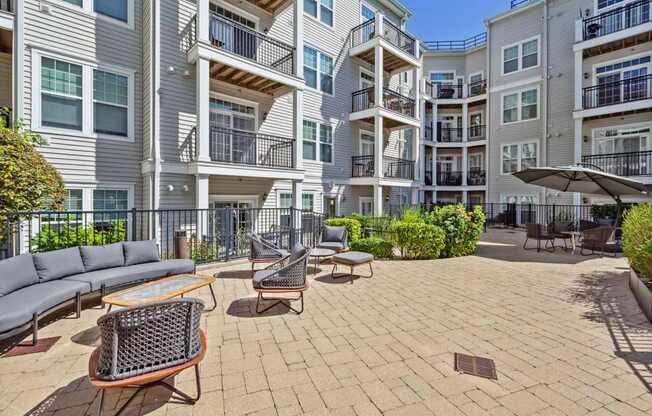A sunny day at a patio with a table and chairs.
