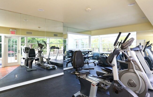 a gym with cardio equipment and windows in a building