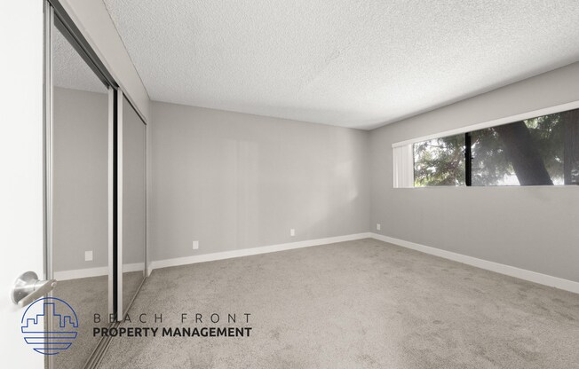 the spacious living room of a manufactured home with carpet and a large window