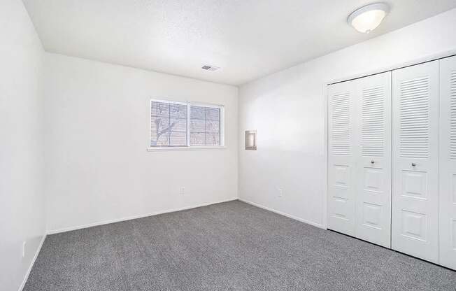 A room with white walls, a window, and a row of white lockers.