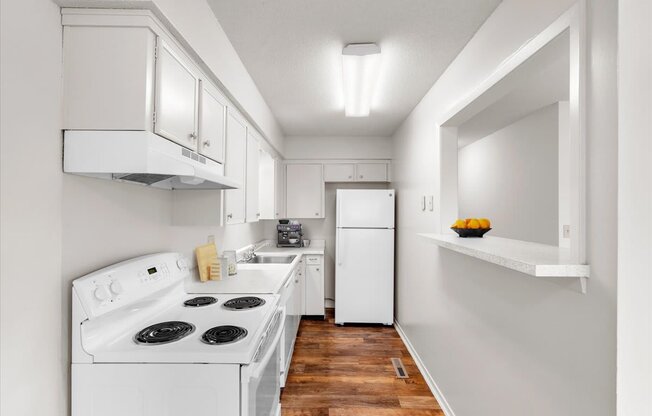 a white kitchen with white appliances and white cabinets