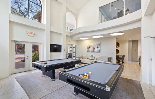 a resident clubhouse with two pool tables and a flat screen tv