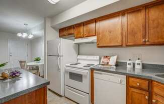 a kitchen with white appliances and wooden cabinets