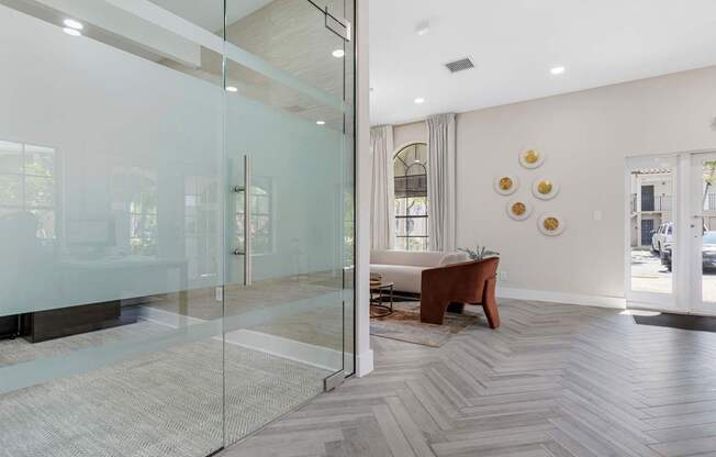 A modern living room with a glass door and a wooden chair.