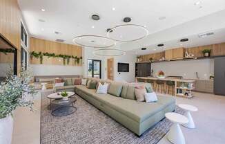 A modern living room with a large sectional sofa and a coffee table in the center.