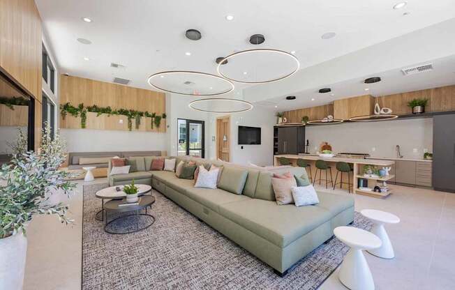 A modern living room with a large sectional sofa and a coffee table in the center.