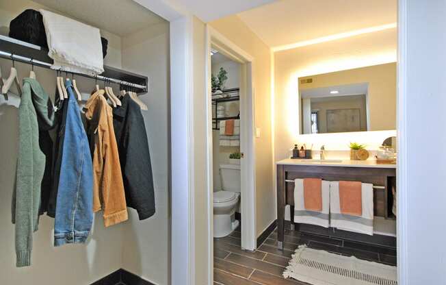 a view of a bathroom and a closet with towels and a sink and a toilet